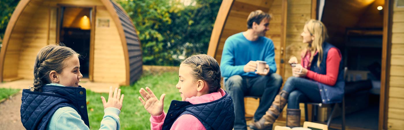 Family outside Whitemead Forest Park glamping pods